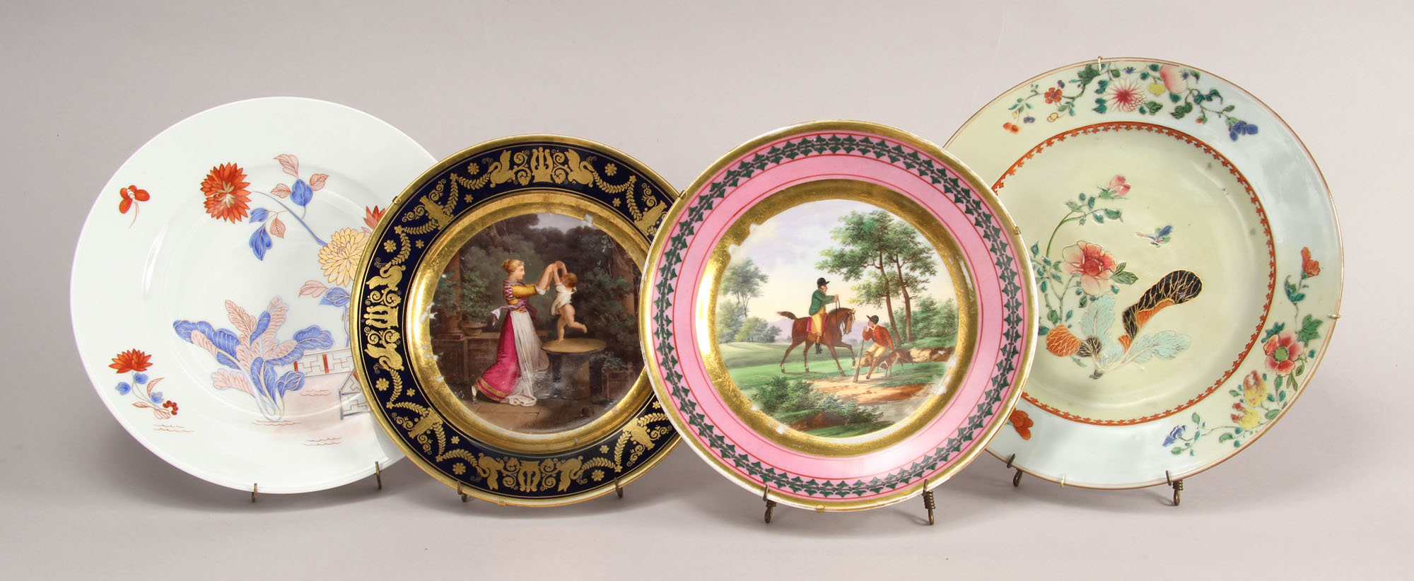  CONJUNTO FORMADO POR CUATRO ANTIGUOS PLATOS DE PORCELANA.