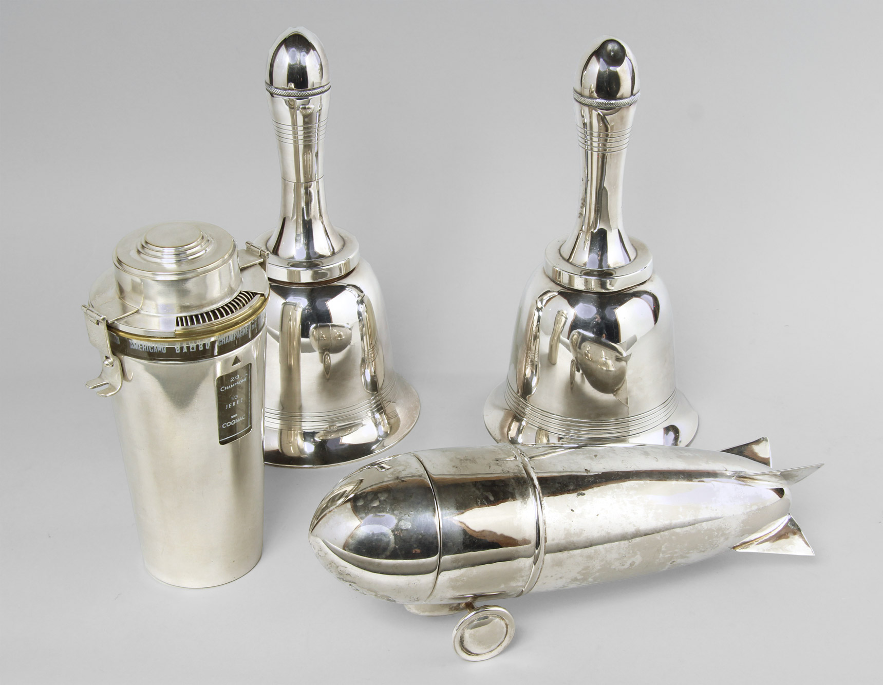 Lotes 541, 542 y 543: 
																		COCKTELERA 'THE BARMAN' DE LA CASA GHISO.
																		COCKTELERA DE METAL PLATEADO EN FORMA DE ZEPPELIN.
																		PAR DE COCKTELERAS INGLESAS EN FORMA DE CAMPANA. 