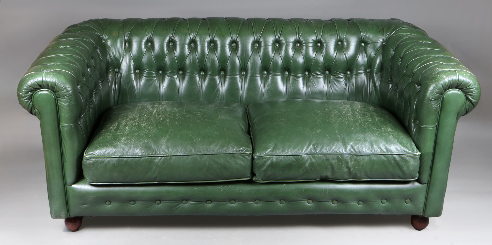  PEQUEÑO SOFA CHESTERFIELD TAPIZADO EN CUERO VERDE. 