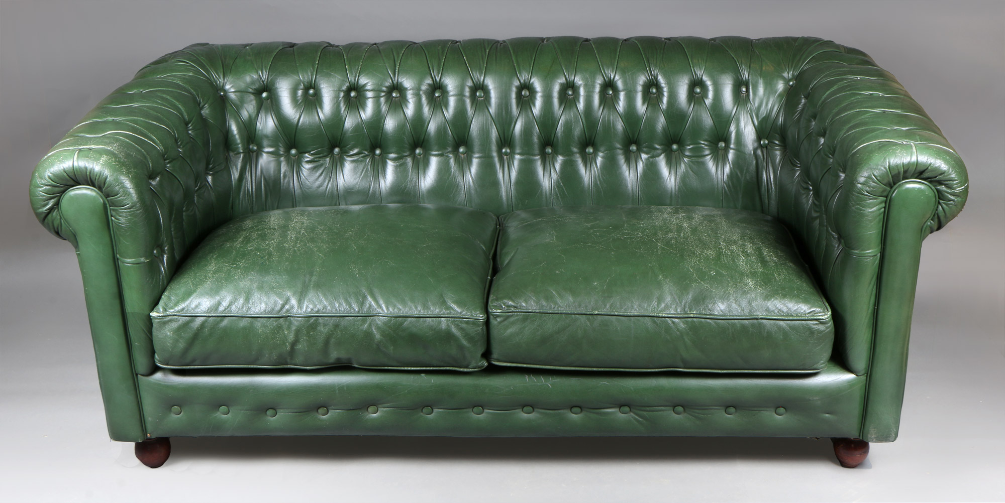  PEQUEÑO SOFA CHESTERFIELD TAPIZADO EN CUERO VERDE. 