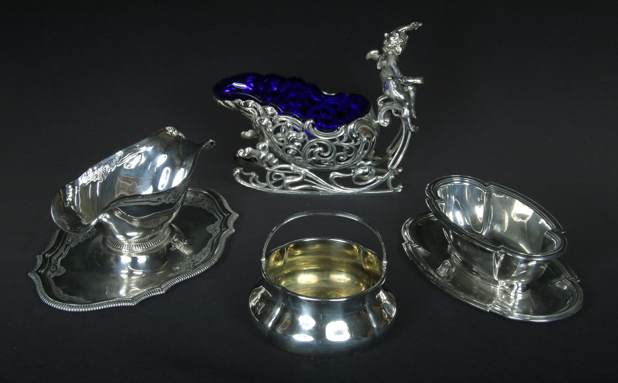 Lotes 685, 686: 
																		SALSERA ALEMANA DE METAL WMF CON RECIPIENTE DE VIDRIO.
																		DOS SALSERAS DIFERENTES DE PLATA 900 SELLADA. 