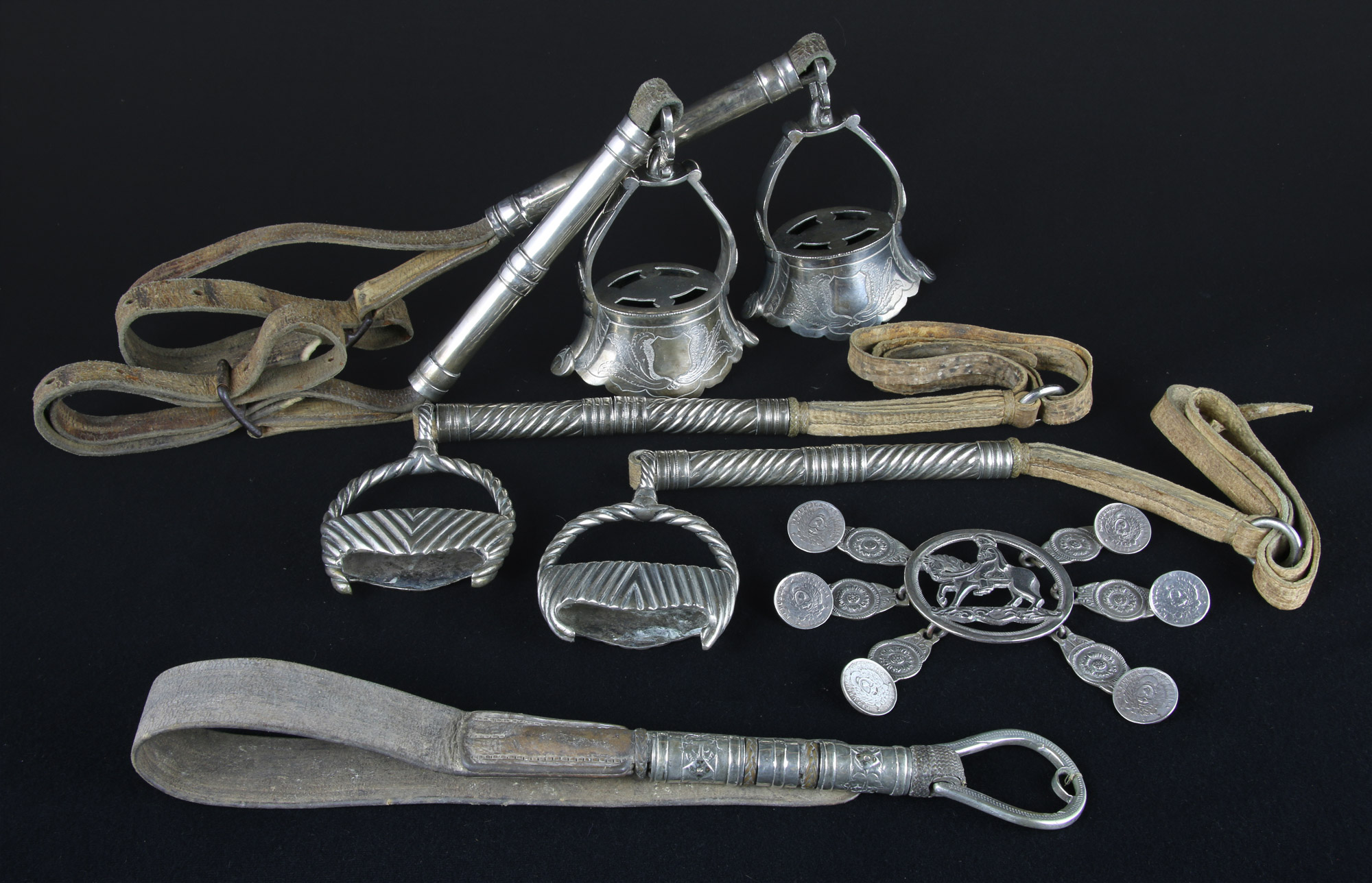 Lotes 536, 537, 538 y 539: 
																		PAR DE ANTIGUOS ESTRIBOS CAMPANA PORTEÑOS. 
																		PAR DE ESTRIBOS PORTEÑOS DEL SIGLO XIX.
																		ANTIGUA RASTRA PORTEÑA DEL SIGLO XIX. 
																		ANTIGUO REBENQUE DE ARGOLLA PORTEÑO DEL SIGLO XIX.